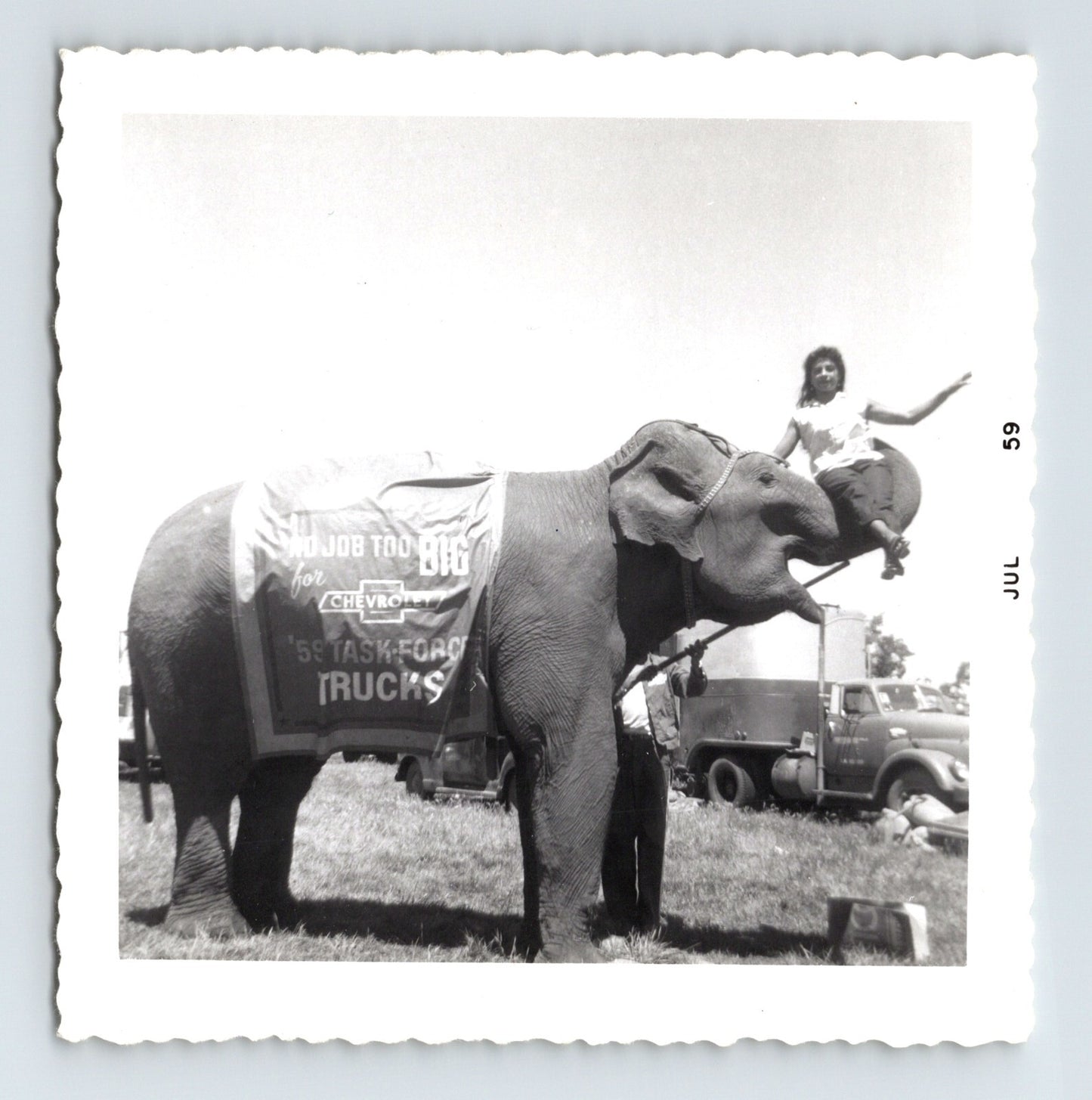 Vintage 1959 photograph of Kelly Miller Circus elephant with rider and Chevrolet Task Force truck advertisement banner in Hugo Oklahoma