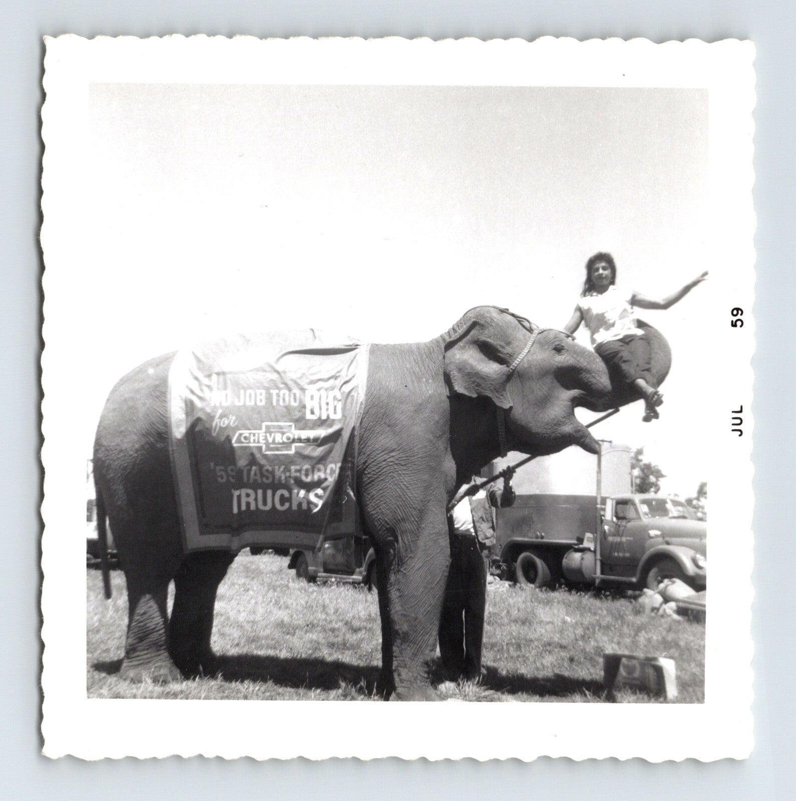 Vintage 1959 photograph of Kelly Miller Circus elephant with rider and Chevrolet Task Force truck advertisement banner in Hugo Oklahoma