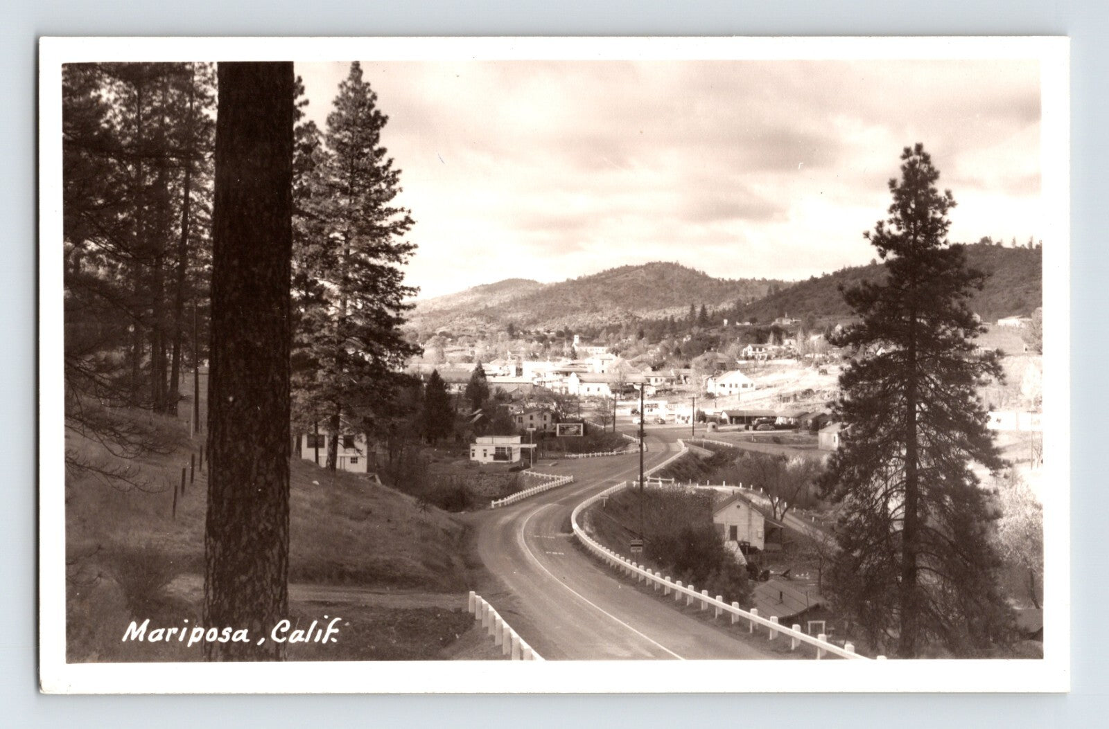 1950s Mariposa California Southern Entrance Road curving highway view with pine trees hillside homes and Sierra foothills