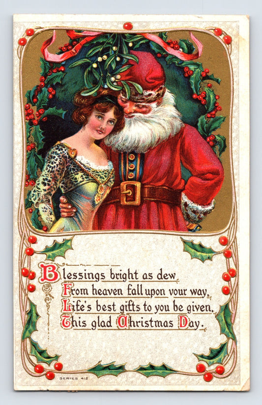 Santa Claus beside a young Edwardian woman beneath mistletoe and holly border on an ornate embossed Christmas postcard with holiday verse.