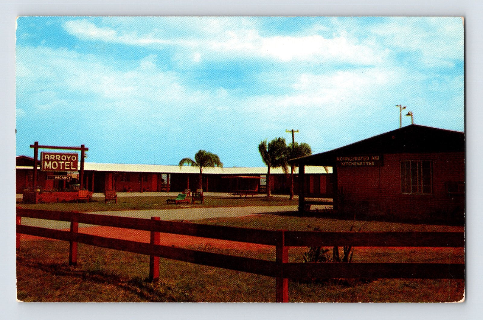 Harlingen Texas Arroyo Motel roadside view with sign fenced grounds and low motor court buildings 1960s postcard