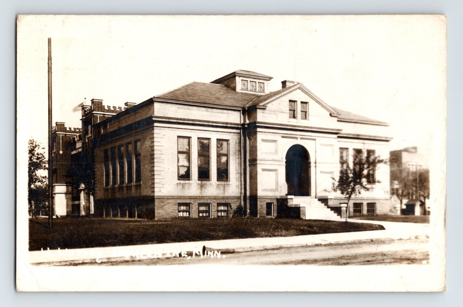 Sauk Centre Minnesota public library building 1921 real photo postcard with classical architecture arched entrance and early streetscape setting