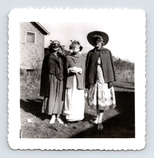 Halloween women masks capes costumes backyard house mid century snapshot three women posing outdoors 3.5 x 3.5 photo