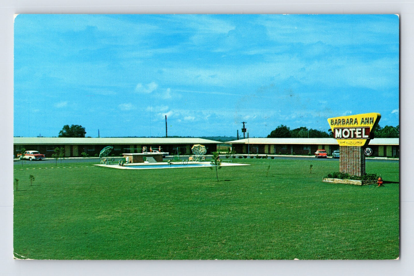 Chrome postcard of Barbara Ann Motel in Ozark Alabama showing roadside sign, swimming pool, and single-story motor court along Highway 231