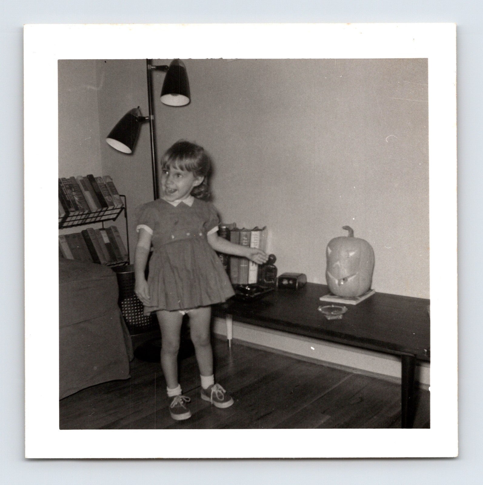 Vintage Halloween snapshot smiling girl jack o lantern living room mid century 1950s square photo