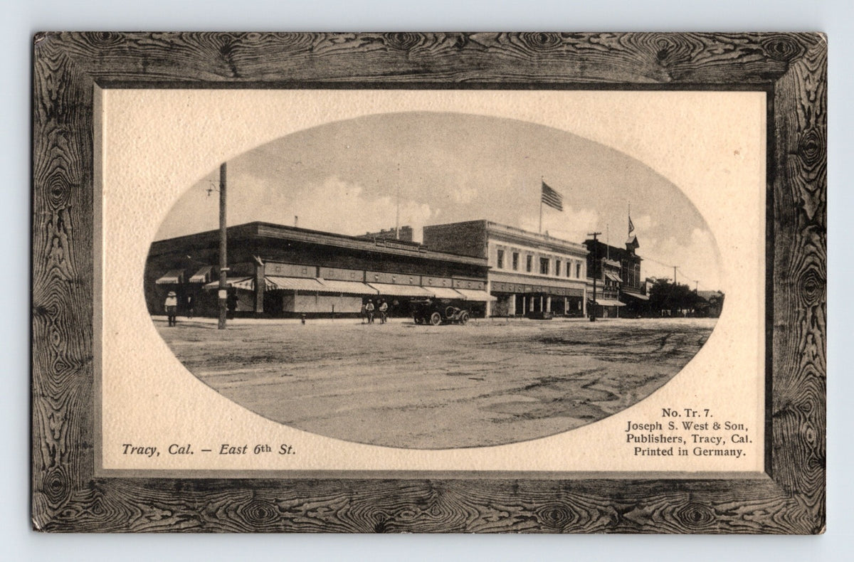 Black and white postcard of East 6th Street downtown Tracy California with oval vignette and printed frame border