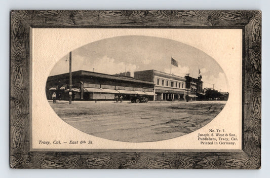 Black and white postcard of East 6th Street downtown Tracy California with oval vignette and printed frame border