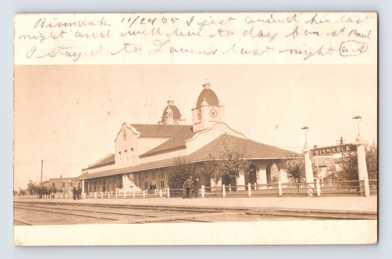 1905 real photo postcard of Bismarck North Dakota railroad train station depot with tracks in foreground and handwritten message at top