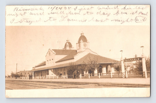 1905 real photo postcard of Bismarck North Dakota railroad train station depot with tracks in foreground and handwritten message at top