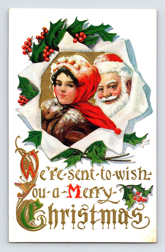 Santa Claus and young woman framed by holly and ribbon on embossed Christmas postcard with ornate gold lettering and holiday greeting.