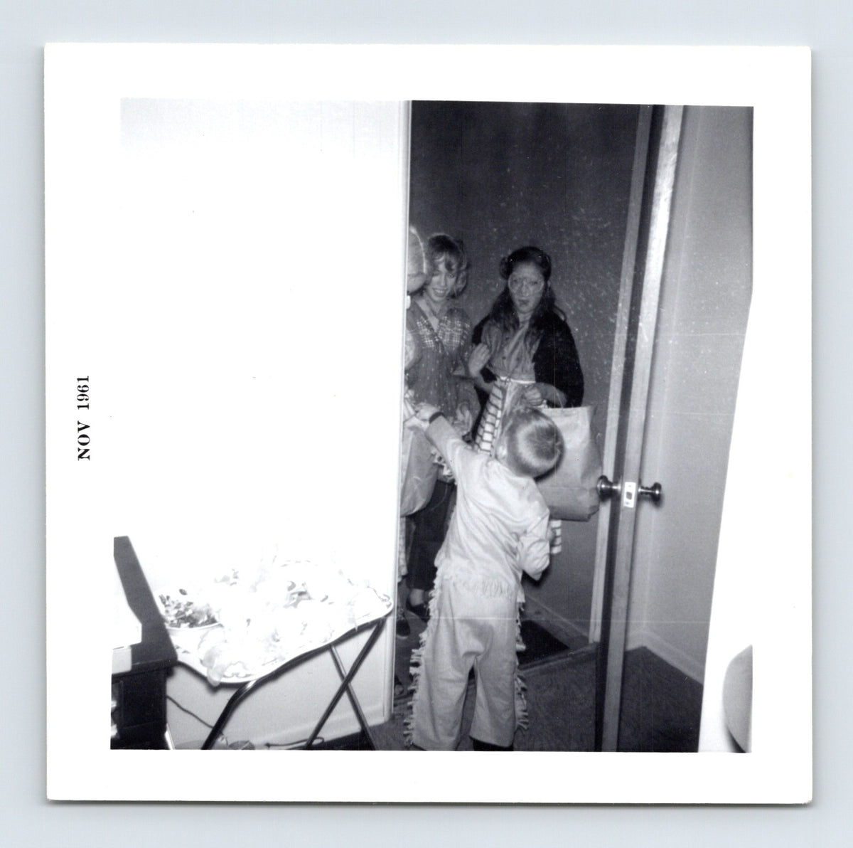 Halloween trick or treat child doorway candy exchange November 1961 snapshot costume home interior 3.5 x 3.5 photo
