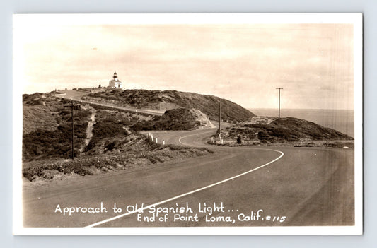 Point Loma California Old Spanish Lighthouse coastal road real photo postcard showing winding roadway and ocean bluff approach.