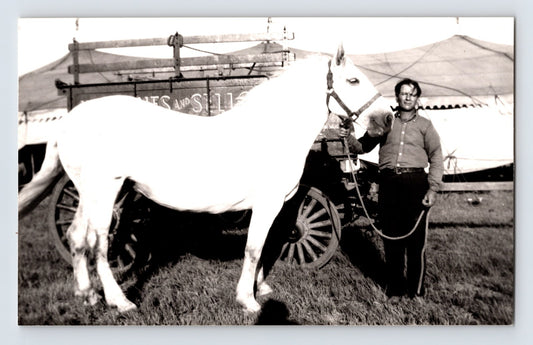 Barnes Sells Floto Circus horse trainer standing with white horse beside circus wagon 1940s circus lot photograph