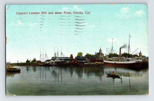 Harbor view of Carson’s Lumber Mill and waterfront in Eureka, California, showing steamship at dock, lumber stacks, small rowboat in foreground, and calm water reflections.