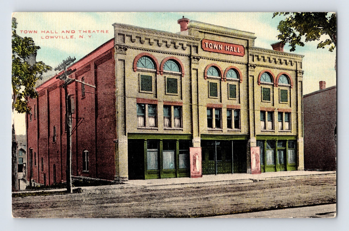 1910s postcard of Town Hall and Theatre in Lowville New York showing ornate two-story civic building with arched windows and streetfront facade