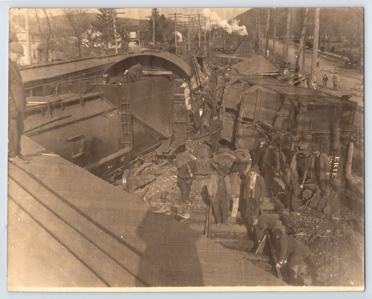 Antique photo showing Erie Railroad train wreck in Suffern New York with overturned cars and workers 1910s