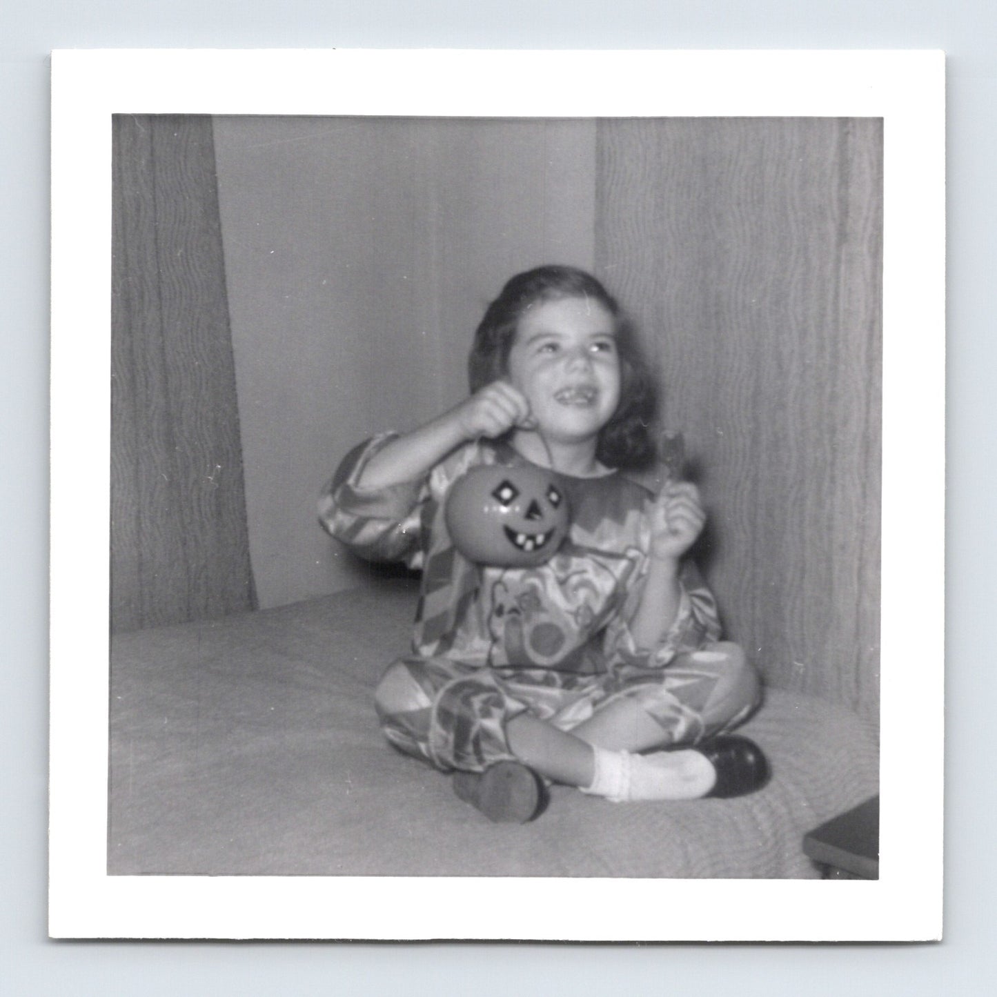 Vintage Halloween girl costume pumpkin bucket sitting on couch 1957 snapshot black white photo