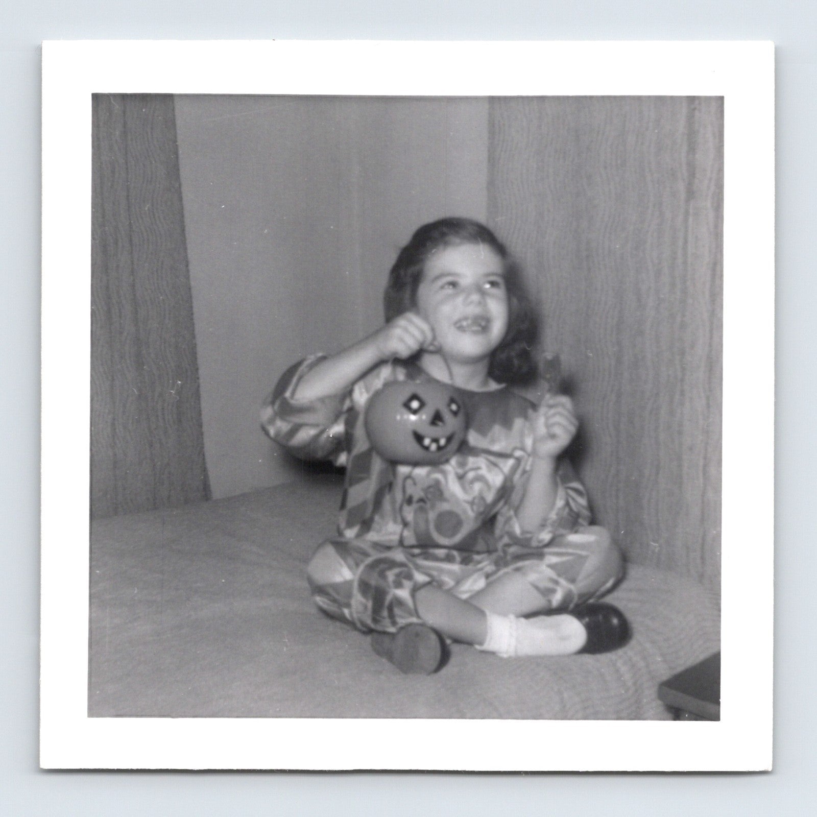 Vintage Halloween girl costume pumpkin bucket sitting on couch 1957 snapshot black white photo