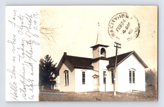 Real photo postcard of Ladora Iowa church building with front cancel dated February 18 1907 and handwritten message along left margin