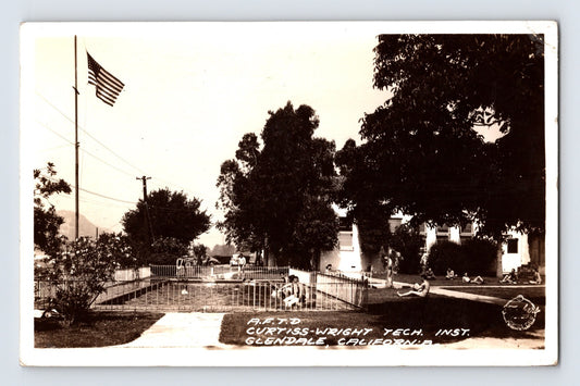Curtiss Wright Technical Institute flight school campus with fenced pool area and American flag in Glendale, California, 1942 real photo postcard.