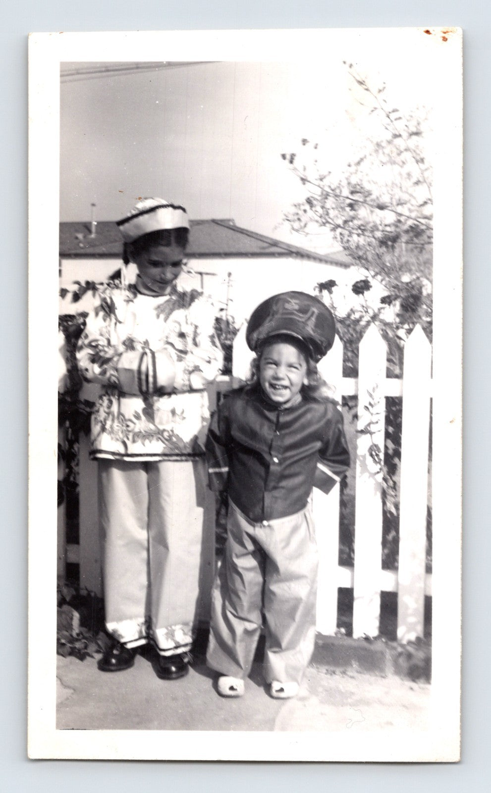 Children Halloween costumes Asian outfit hat smiling yard white fence vintage snapshot