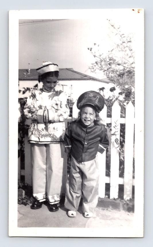 Children Halloween costumes Asian outfit hat smiling yard white fence vintage snapshot