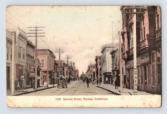 Hand-colored postcard showing Second Street in downtown Eureka, California, with storefronts, pedestrians, and early street scene; divided back format.