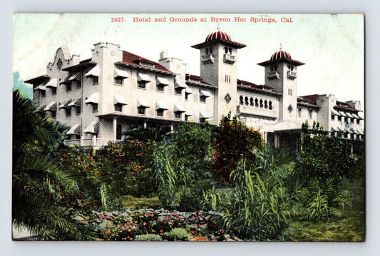 Antique postcard view of the Hotel and Grounds at Byron Hot Springs California with twin red domed towers and landscaped gardens in foreground