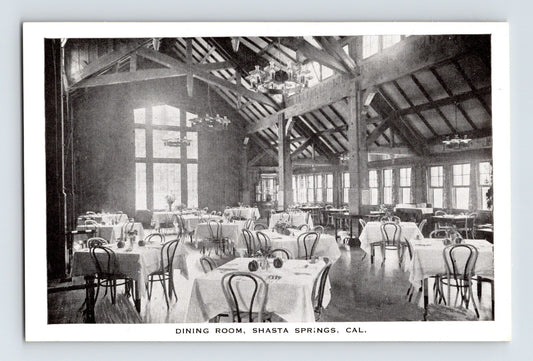 Vintage black and white photo of a dining room with tables and chairs in Shasta Springs, California.