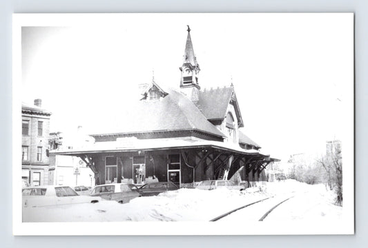 Real photo postcard of Leominster Massachusetts railroad train station depot in winter with snow covered ground and tracks