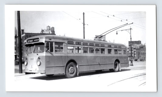 Chicago Surface Lines trolley bus 3067 on Route 57 Flushing Avenue Brown Place with overhead wires and Mason’s Peas sign in background black and white photo