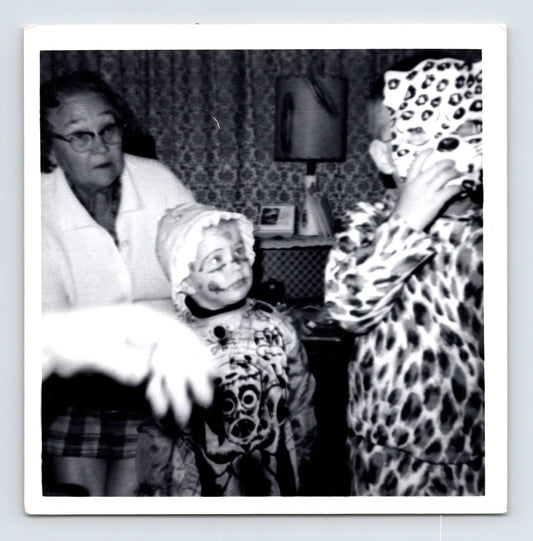 Child Halloween costumes clown and leopard with older woman indoors 1960s snapshot photo