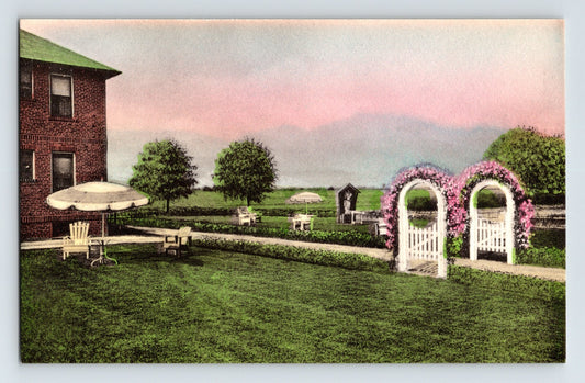 Hand-colored postcard of Lady Consolation Residence grounds in Amityville Long Island New York with garden arches and lawn seating