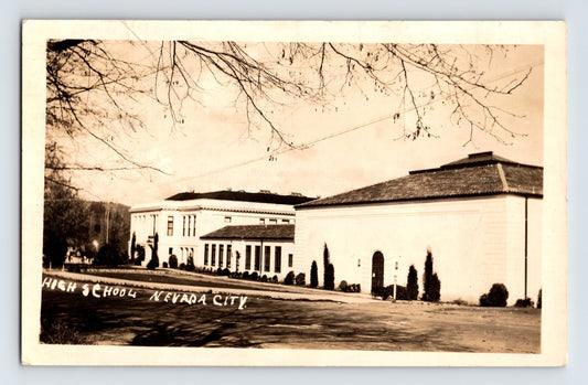 Real photo postcard of Washington School in Nevada City California showing long stucco school building with students gathered along the facade.