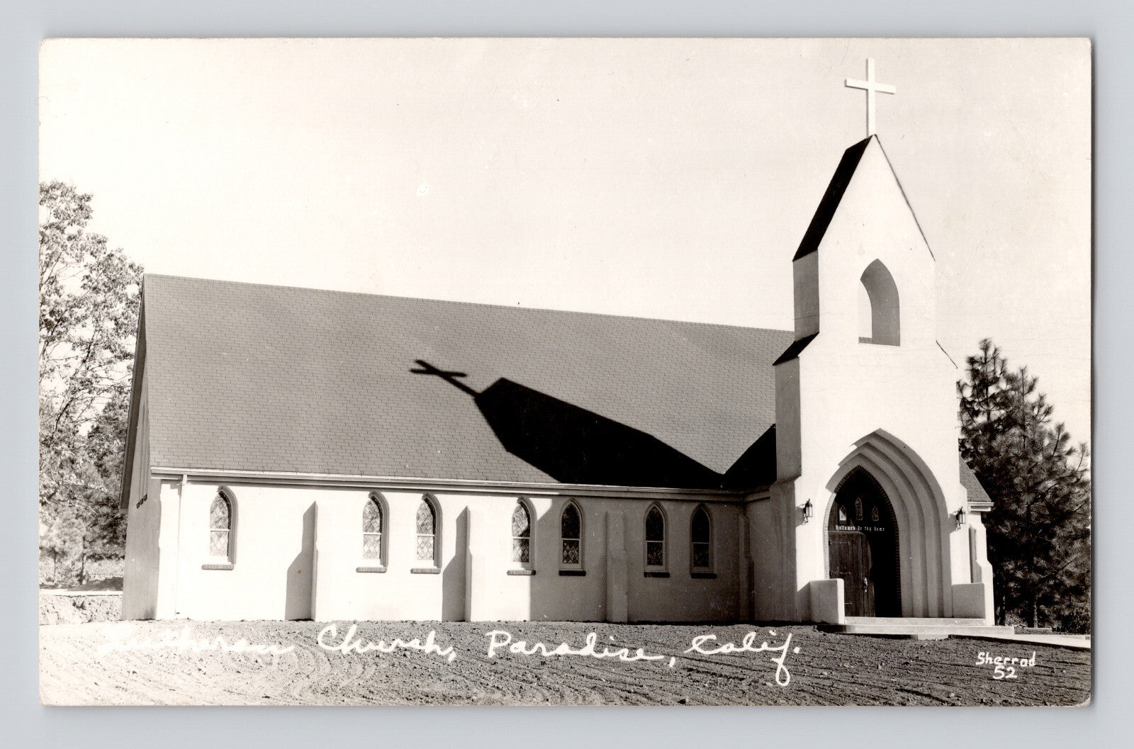 Real photo postcard of Lutheran Church in Paradise California showing a white stucco church with arched entry tower and cross