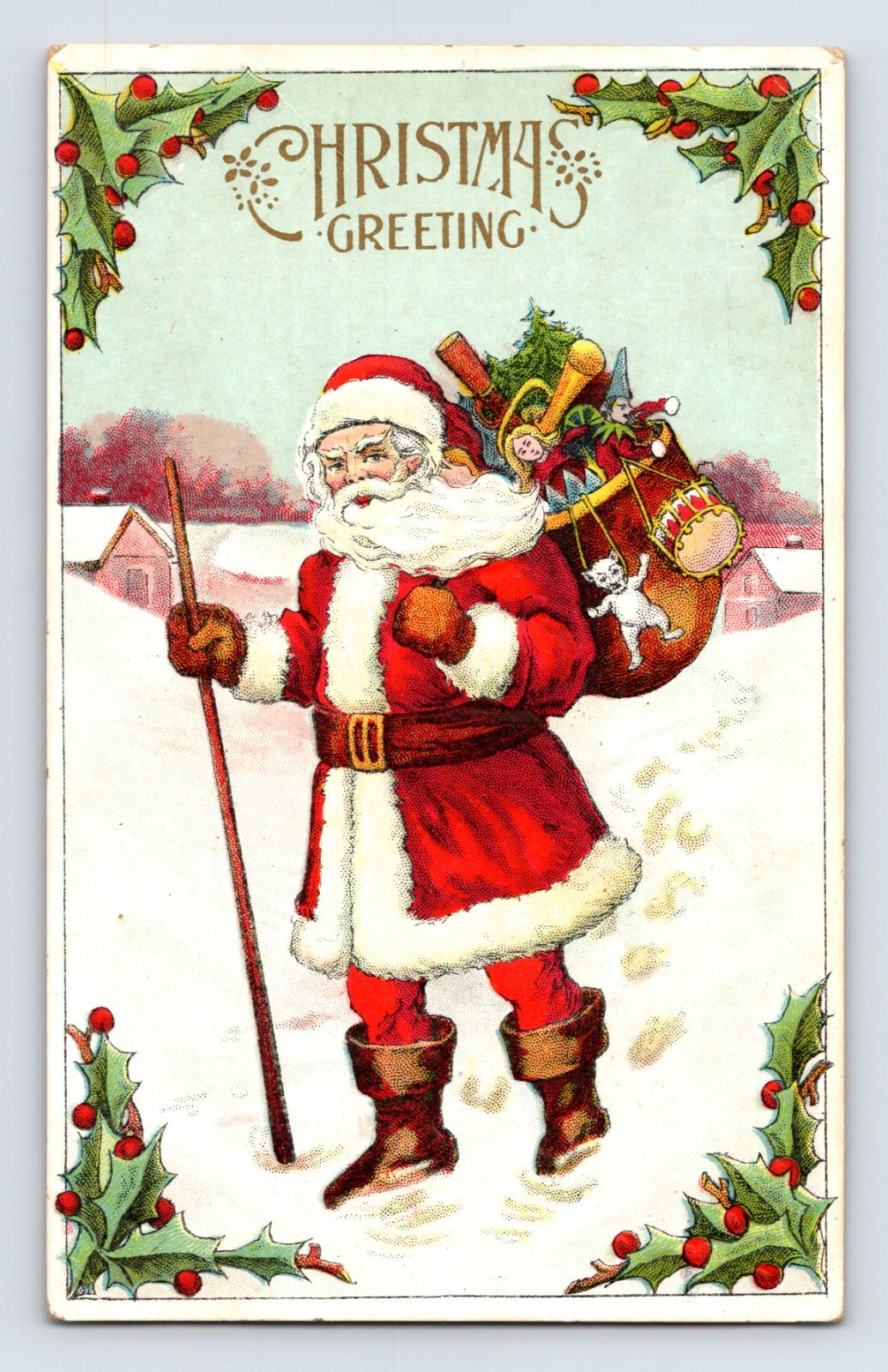 Santa Claus carrying sack of toys through snowy village framed by holly border on vintage Christmas greeting postcard.