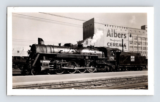 Black and white photograph showing Western Pacific Railroad 4-8-2 steam locomotive No 171 at Oakland California with Albers Cereal building in background 