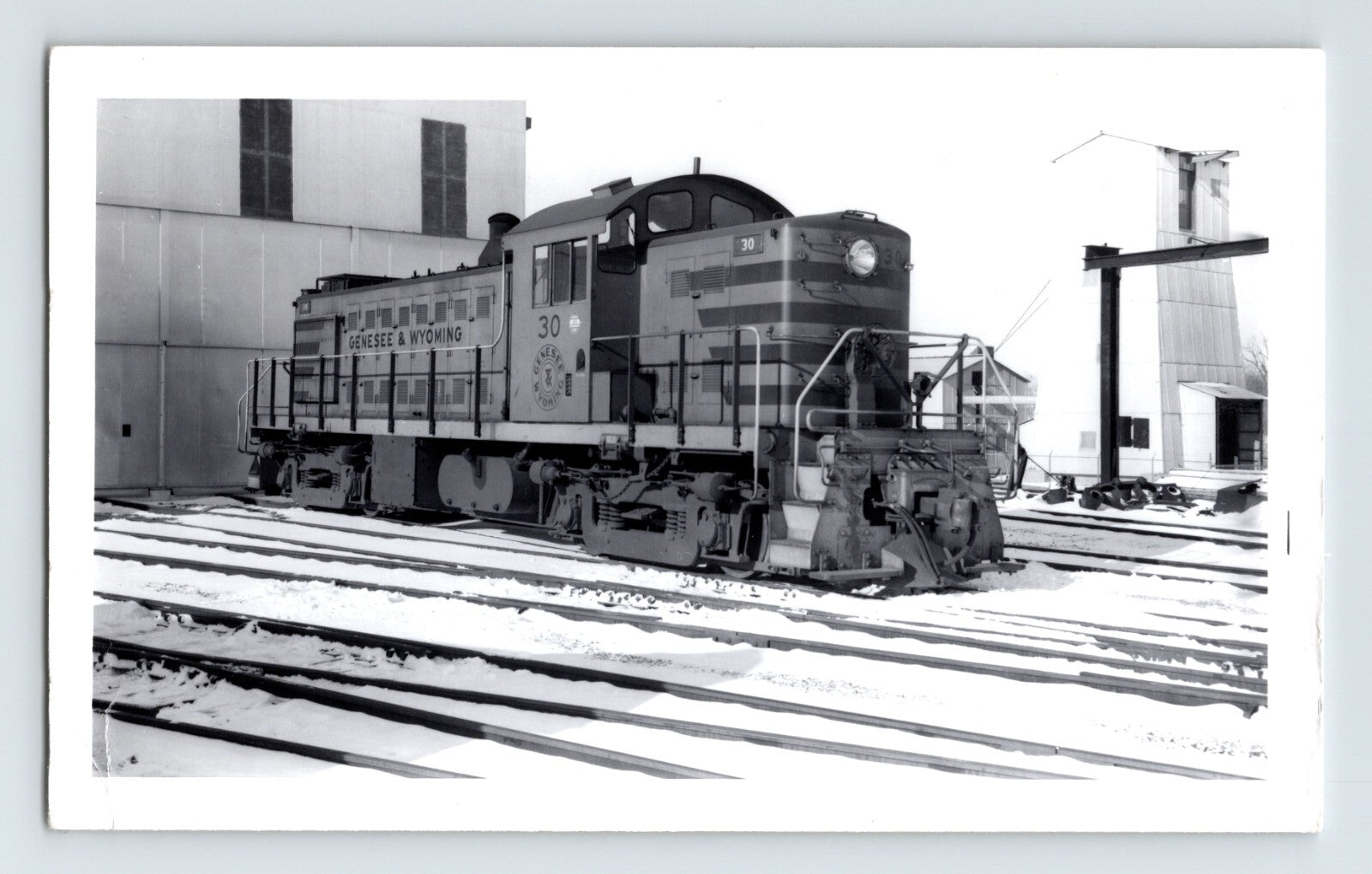 Genesee Wyoming railroad switcher locomotive in snow 1950s black and white train yard photo