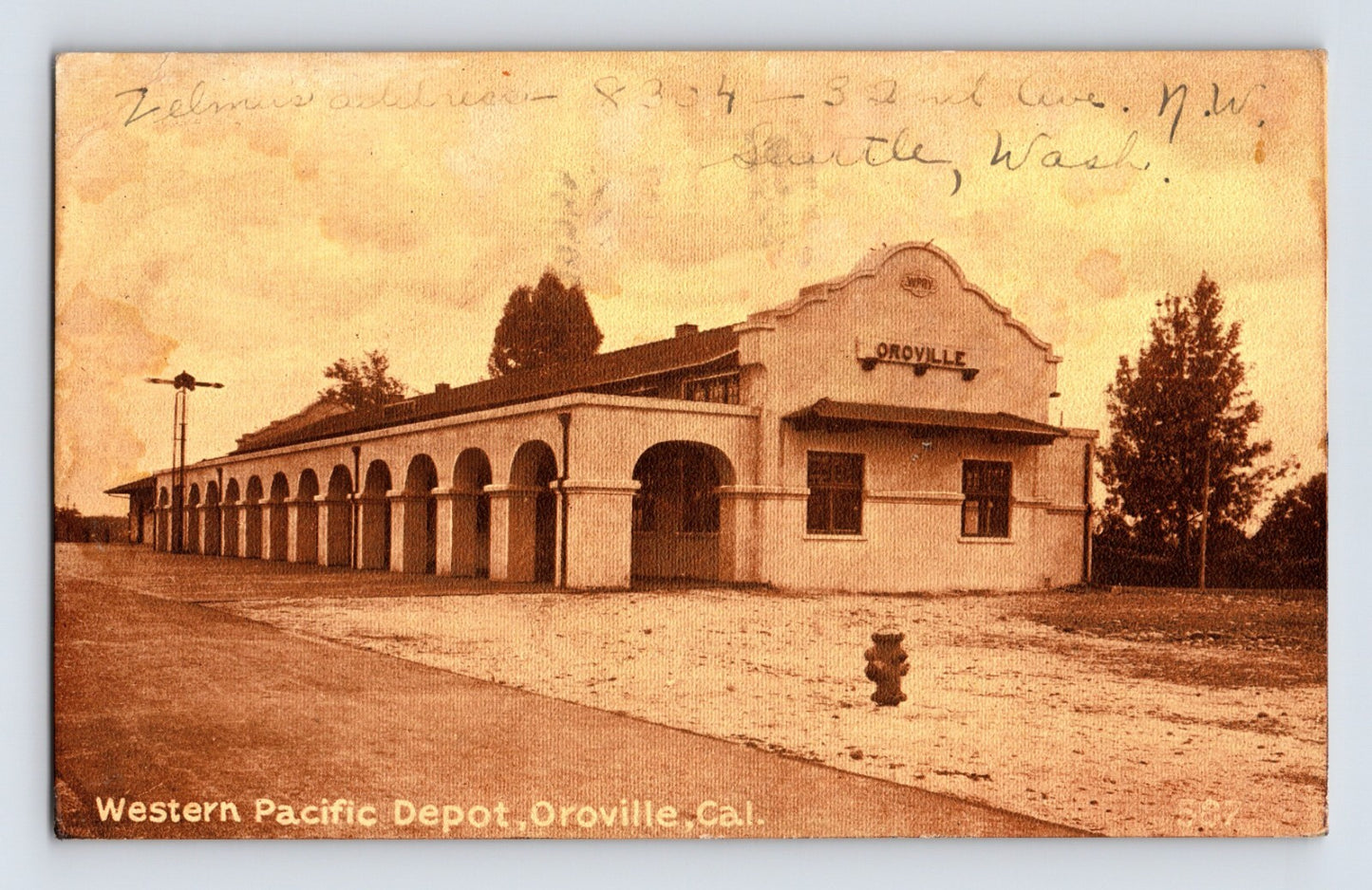 Western Pacific Depot in Oroville California showing long arched arcade train station building with street frontage and sepia photographic detail