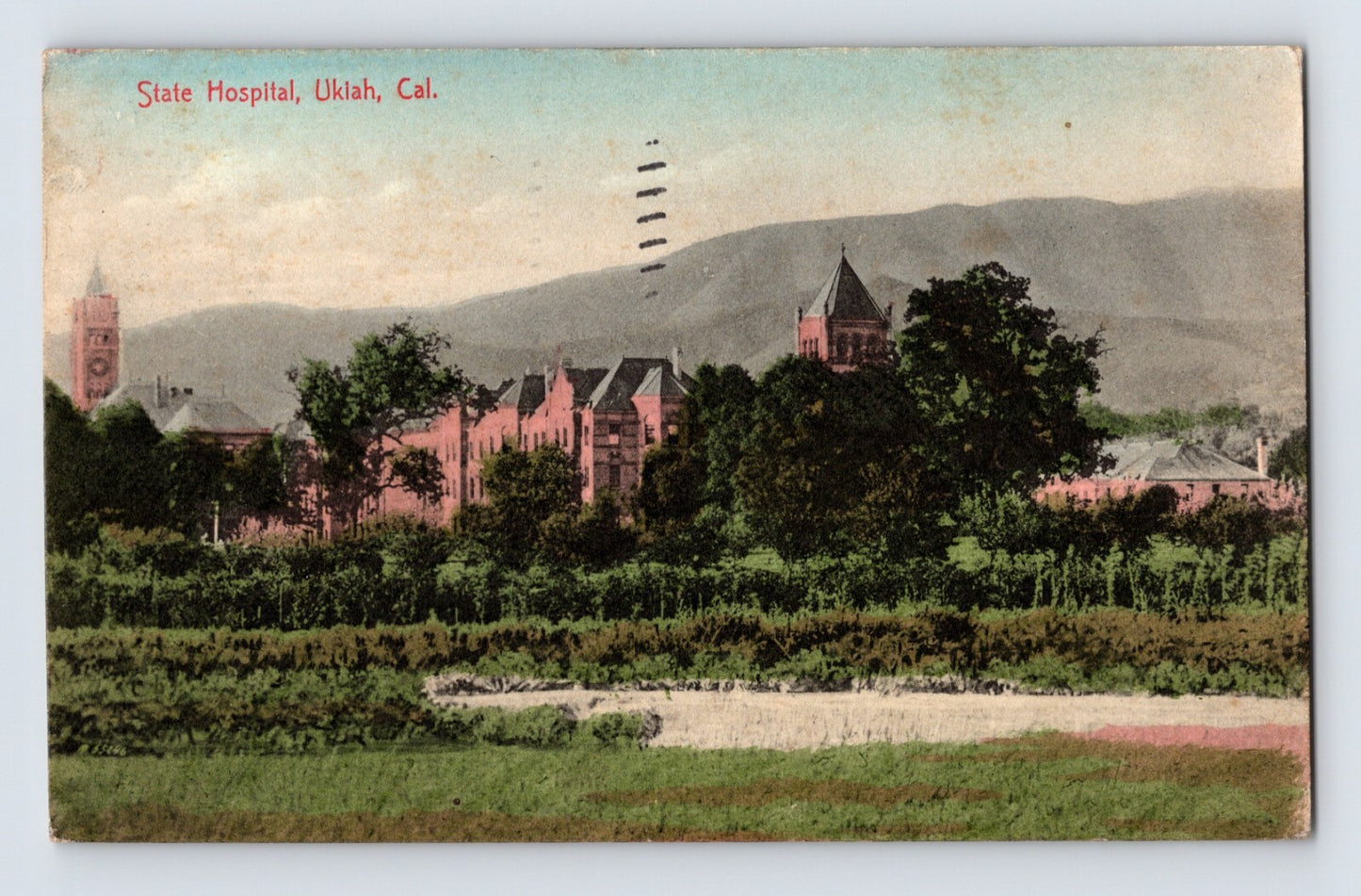 Colorized view of State Hospital buildings with tower and surrounding grounds in Ukiah California 1910s postcard