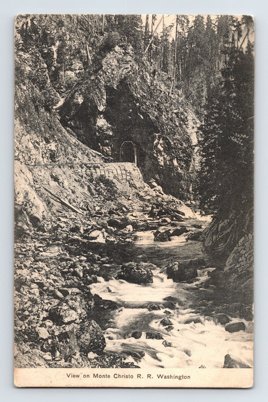 View of Monte Cristo Railroad tunnel entrance with creek and rock cut Washington 1911 postcard
