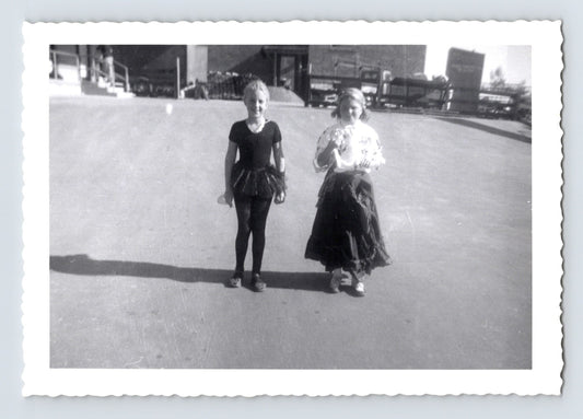 Two girls Halloween costumes ballerina and dress schoolyard pavement mid century snapshot