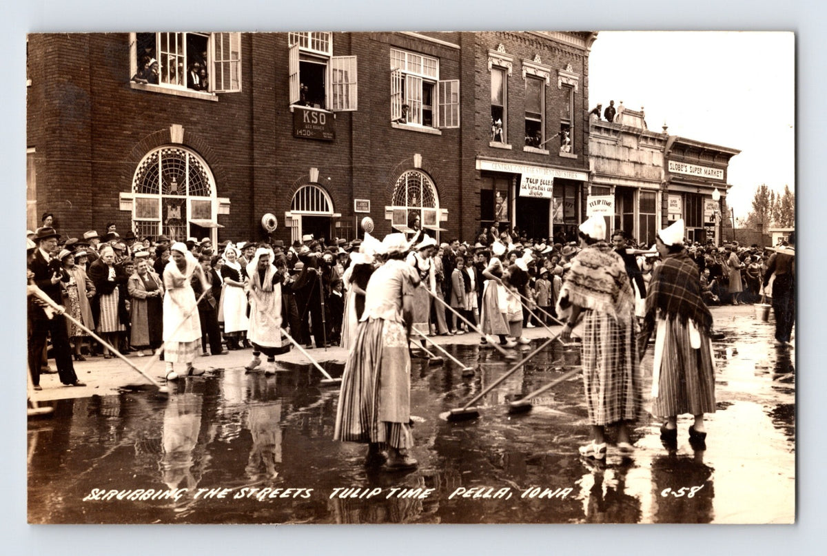Tulip Time street scrubbing Pella Iowa 1940 real photo postcard with women in traditional dress and downtown storefronts