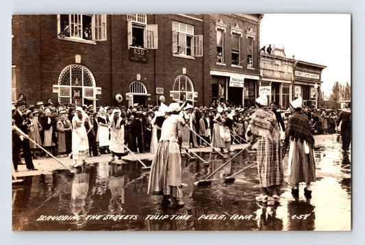Tulip Time street scrubbing Pella Iowa 1940 real photo postcard with women in traditional dress and downtown storefronts