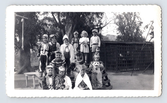 Halloween children group costumes skeleton clown masks schoolyard 1950s photo