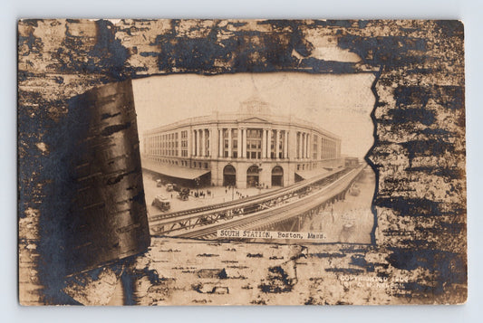 1907 real photo postcard showing South Station in Boston, Massachusetts, framed within a decorative birch bark novelty design with elevated rail approaches and station crowds visible below.