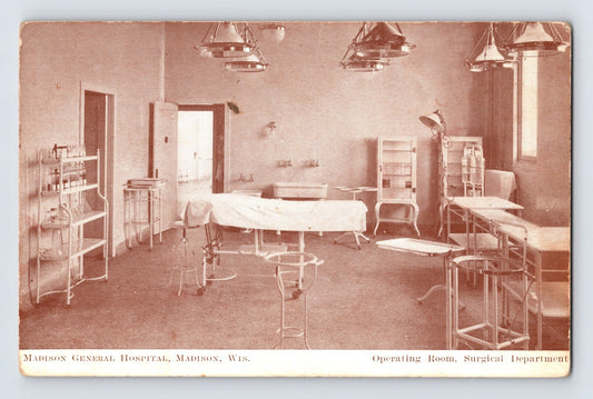 1910s postcard of Madison General Hospital operating room in Madison, Wisconsin with central surgical table, overhead lamps, metal instrument stands, and glass cabinets