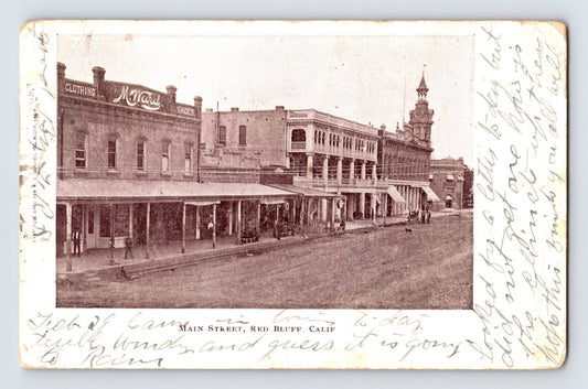 Red Bluff California Main Street postcard showing early downtown storefronts, covered sidewalks, and the Tehama County courthouse clock tower.