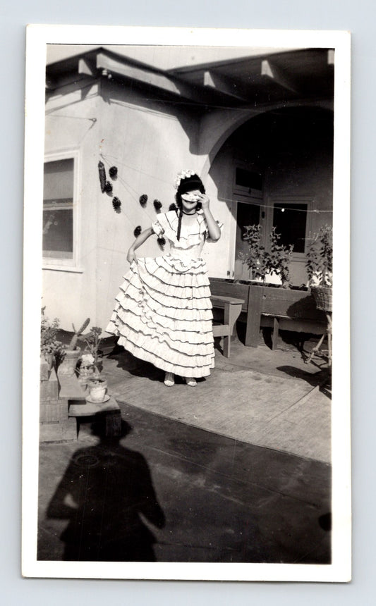 Girl Halloween costume ruffled dress mask patio mid century home black and white snapshot