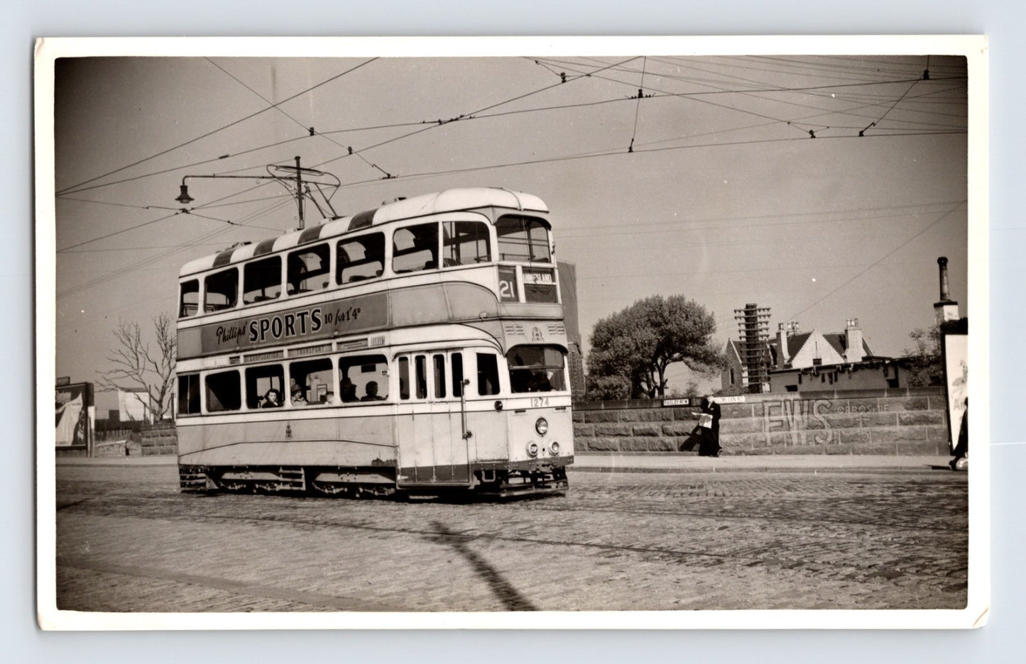 British double deck tram Route 21 West Island Phillips Sports advert cobbled street 1930s
